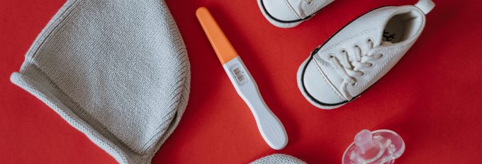 Close up shot of pregnancy test near baby s things