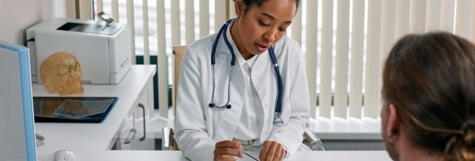 Man in white dress shirt sitting at the table escourting his wife to do an abortion