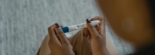 Overhead shot of a person holding a positive pregnancy test